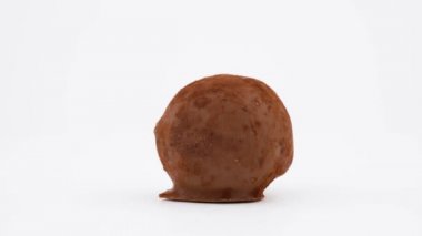Bir sütlü çikolata el yapımı tatlı. Truffle şeker. Turntable döner. Beyaz arka plan üzerinde izole. Yakın çekim. Makro.