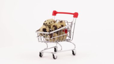 Çiğ Bıldırcın yumurta kazık pikap üzerinde dönen ile süpermarket arabası. Beyaz arka plan üzerinde izole. Yakın çekim. Makro.