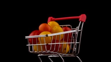 Süpermarket arabası makro çekim Paketli kırmızı ve sarı üzüm domates kazık. Turntable döner. Siyah arka plan üzerine izole. Yakın çekim.