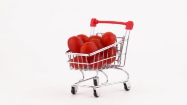 Alışveriş sepeti kırmızı üzüm domates kazık su damlaları ile dolu. Turntable döner. Beyaz arka plan üzerinde izole. Yakın çekim. Makro.