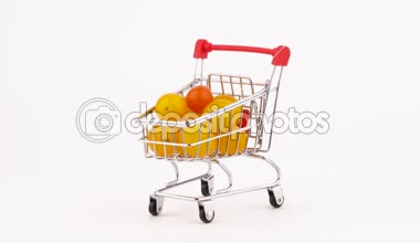 Süpermarket arabası sarı kiraz domates yığın ile Paketli. Turntable döner. Beyaz arka plan üzerinde izole. Yakın çekim. Makro.