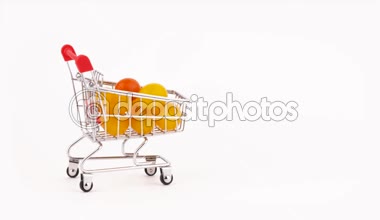 Süpermarket arabası hareket sarı üzüm domates yığın ile Paketli. Beyaz arka plan üzerinde izole. Yakın çekim. Makro.