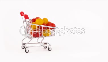 Süpermarket arabası hareket Paketli kırmızı ve sarı üzüm domates kazık. Beyaz arka plan üzerinde izole. Yakın çekim. Makro.