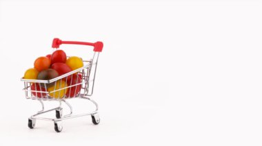 Yarım çerçeve. Alışveriş sepeti ile çok renkli üzüm domates kazık Paketli. Turntable döner. Beyaz arka plan üzerinde izole. Yakın çekim. Makro.