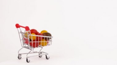 Süpermarket arabası hareket çok renkli üzüm domates yığın ile Paketli. Beyaz arka plan üzerinde izole. Yakın çekim. Makro.