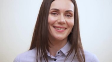 Gülümseyen ve kameraya doğru seyir oldukça uzun saçlı esmer bir portresi