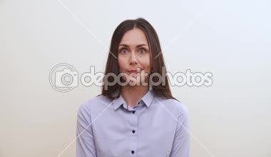 Uzun saçlı esmer gözlerini rulo, biraz sırıtır, parmaklarını ağzına koyar ve onları biraz ısırır