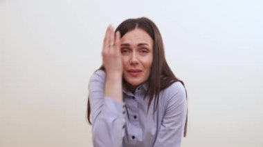Güzel bir esmer sağ gözü şaşı ve yardım kapsar, elini altına koyar, bir şey onu göz grevler denetler