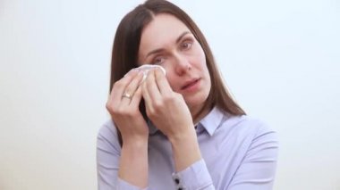 Yanağı silerek bir uzun saçlı esmer ve bir doku ile gözlerinin altında bir yakın çekim. O burnunu darbeler ve kabartmalı sighs