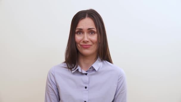 A brunette makes faces of disgust, shows the tip of the tongue and smiles slightly — Stock Footage Brunette Makes Faces Disgust Shows Tip Tongue Smiles Slightly Royalty Free Stock Video