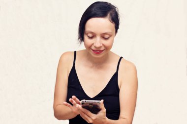 Senin smartphone içinde okur büyük bir ilgi ile gülümseyen kadın.