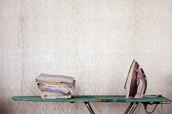 Electric iron and ironed linen on the Ironing Board.