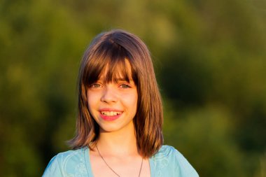 Batan güneşin aydınlattığı gülümseyen ve güzel bir kızın portresi..