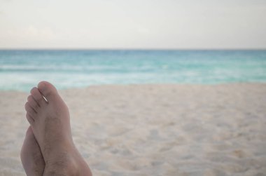 Ayağa kadar mavi Karayip Denizi bakan bir plaj sandalyesi ile rahatlatıcı.