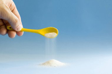 Mavi arka planda sarı kaşık döndürme şekeri