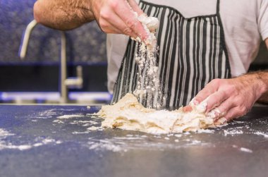 Siyah granit masada pizza hamuru hazırlayan adam.