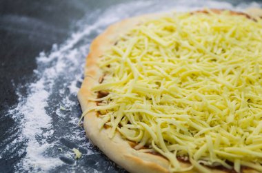 Pizza, pizza hamur domates sosu ve mozzarella peyniri ile yakın çekim hazırlanıyor.