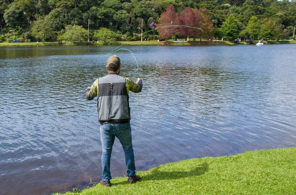 Pesca a mosca sul lago in Brasile, pesca giovane pescatore . — Foto Stock