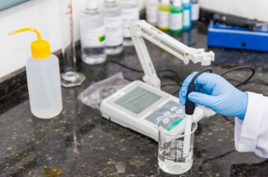 Kadın elleri ph metre elektronik enstrüman üzerinde ph testi yapıyor