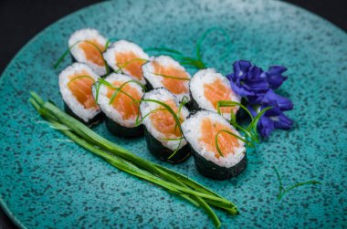 Mükemmel suşi, geleneksel Japon mutfağı. Süslü tabakta nefis Hossomaki, siyah arka plan..