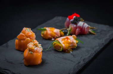 Suşi, geleneksel Japon mutfağı. Süslü tabakta bir sürü lezzetli suşi, siyah arka plan. Suşi, Urakami, Nigori, suşi jow, sashimi, tekamaki vs. ...