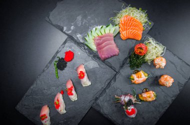 Suşi, geleneksel Japon mutfağı. Süslü tabakta bir sürü lezzetli suşi, siyah arka plan. Suşi, Urakami, Nigori, suşi jow, sashimi, tekamaki vs. ...