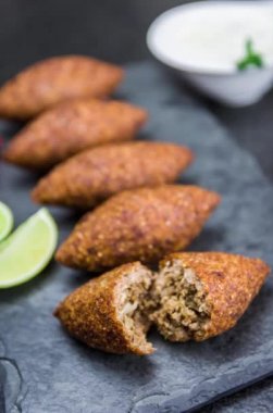 Lezzetli Lübnan yemeği, siyah taş ve granit zemin üzerinde kibbeh (kibe).