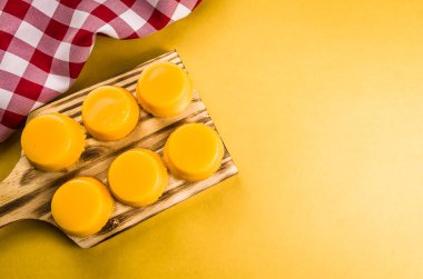 Tahtada lezzetli Quindins, yumurta sarısı, şeker ve hindistan cevizinden yapılmış geleneksel Brezilya tatlısı..