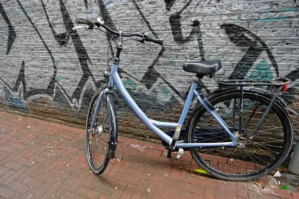 Old Dutch bike against a graffiti wall in Amsterdam Paesi Bassi — Foto Stock