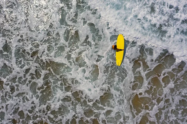 Aerial shot from a surfer going to surf in the ocean — Stock Photo, Image