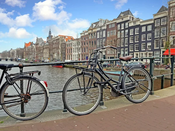 Bicicletas en el puente a lo largo del canal en Amsterdam los Países Bajos —  Fotos de Stock