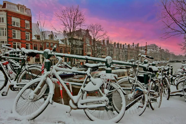 City scenic from snowy Amsterdam in the Netherlands at sunset