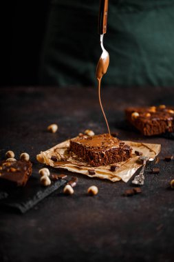 Brownie cake esprisi fındık ve çikolatalı siyah grunge masası.