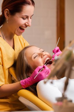 Dişçideki güzel sarışın kadınlar, diş bakımı.