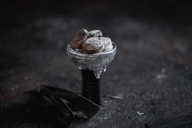 Nargile 'nin kafasında ya da kasesinde sıcak kömür kıvılcımları var. El yapımı, eski, rustik, parıldayan kömür kıvılcımlarıyla altın kaplama. Koyu arkaplan