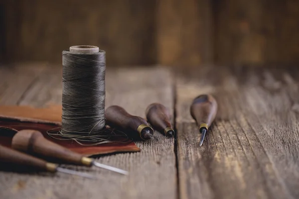 Utensili artigianali in pelle su vecchio tavolo in legno. Laboratorio artigianale in pelle. — Foto Stock