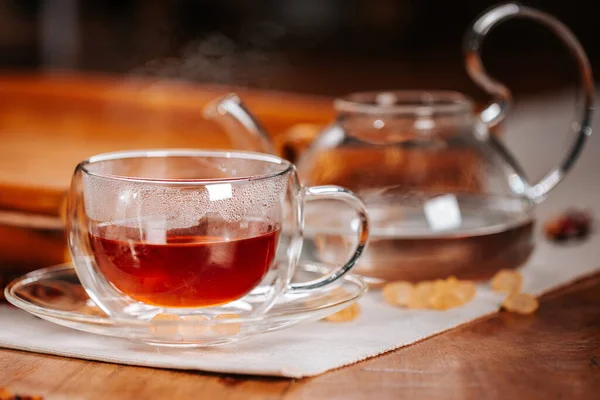 Cup of hot tea with rock sugar, dry tea leaves served in thermo glass tea cup — Stock Photo, Image