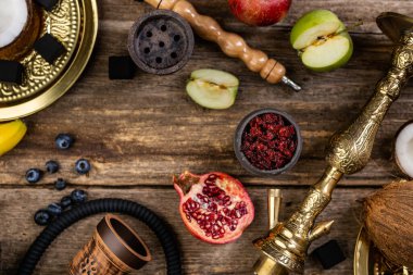 Nargile bileşenlerinin düz yaşam fotoğrafı, meyveli tütünle doldurulmuş taş sisha kafası.
