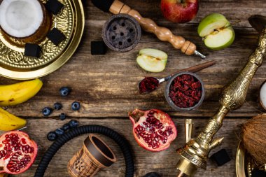 Nargile bileşenlerinin düz yaşam fotoğrafı, meyveli tütünle doldurulmuş taş sisha kafası.