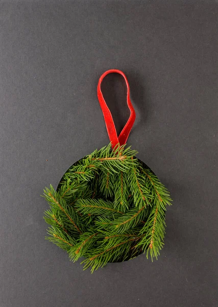 Christmas decoration concept with green fir branches under a black cardboard. Minimalist decoration elements for new year Holidays.