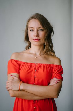 Bir turuncu yaz elbise poz içinde bir genç, çekici Avrupa kadın portresi. O yeşil gözlü sarışın ve güvenle gülümseyen.