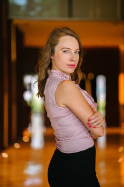 bir genç, uzun boylu, çekici sarışın beyaz bir kadın portresi. O profesyonel ofis kıyafet ve poz giyinmiş 