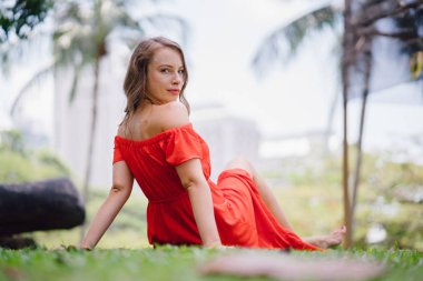 Çim (çim) yalınayak oturan bir seksi, Genç ve çekici beyaz bir kadın portresi. O gülümsüyor gibi rahatlatıcı.