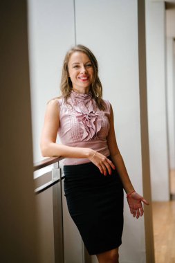 bir genç, uzun boylu, çekici sarışın beyaz bir kadın portresi. O profesyonel ofis kıyafet ve poz giyinmiş 
