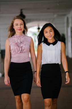 İki iş (bir Çinli Asyalı kadın ve beyaz bir kadın) farklı bir takım portresi. Rahat bir şekilde gülümsüyor musun.