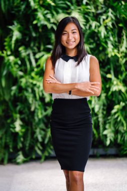  Genç Çinli Asyalı kadın ofis kıyafet içinde bitkilerin yeşil duvara kahkahalarla gülmekten.