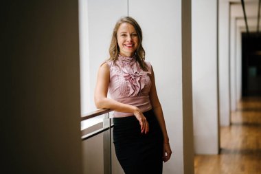 bir genç, uzun boylu, çekici sarışın beyaz bir kadın portresi. O profesyonel ofis kıyafet ve poz giyinmiş 