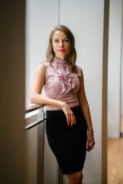 bir genç, uzun boylu, çekici sarışın beyaz bir kadın portresi. O profesyonel ofis kıyafet ve poz giyinmiş 