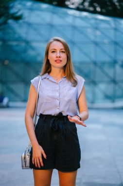 Şehirde poz beyaz beyaz bir kadın portresi. O profesyonel ofis kıyafet ve gülümseyen giymiş 