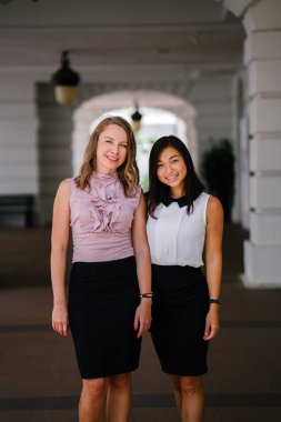 İki iş (bir Çinli Asyalı kadın ve beyaz bir kadın) farklı bir takım portresi. Rahat bir şekilde gülümsüyor musun.